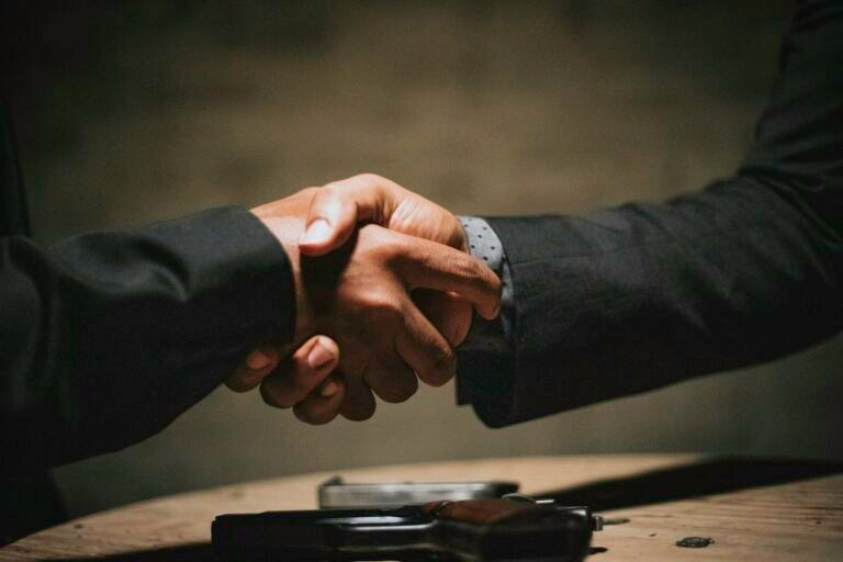 Two people shaking hands over a business deal